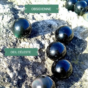 Può includere: Primo piano di perline di pietre preziose nere e verdi. Le perline sono rotonde e lisce. Il testo "OBSIDIENNE" e "OEIL CELESTE" è visibile nell'immagine.