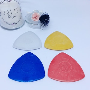 May include: Four triangle-shaped fabric marking tools in white, yellow, blue, and pink. Each tool has a circle in the centre.