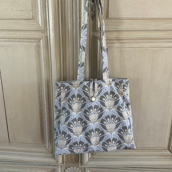 Sac trapèze/tissu ameublement/gris bleu or/doublé velours polyester gris perle/se porte à l’épaule/se ferme par bride et bouton/pratique