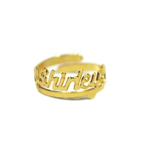 May include: Gold ring with the name "Shirley" written in cursive.
