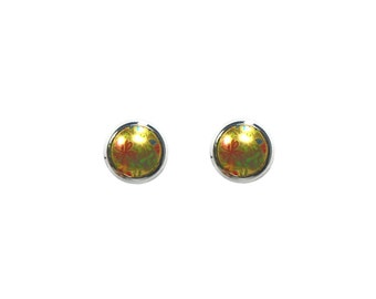 May include: A pair of silver stud earrings with a round, yellow, floral design.