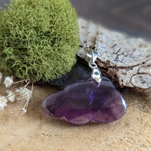 May include: A purple amethyst cloud pendant necklace with a silver chain and bail.