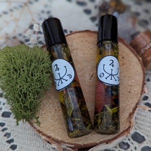 Peut inclure: Deux petits flacons en verre avec des bouchons à bille noirs remplis d'un liquide jaune et d'herbes. Les flacons ont des étiquettes blanches avec un symbole noir et le numéro "24" dessus.