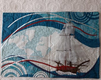 Patchwork fabric painting depicting a sailboat on the sea