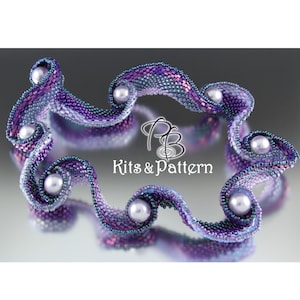 May include: A purple and blue beaded bracelet with a wavy design and silver beads. The bracelet is on a reflective surface.