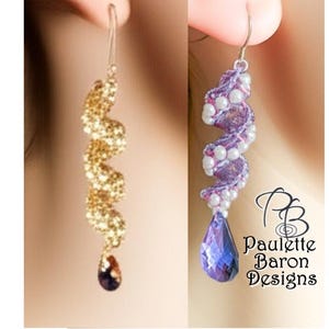 May include: Two pairs of dangle earrings. One is gold-toned with a dark purple teardrop. The other is purple with white accents and a blue teardrop. The earrings are shown on a person's ear. The text "Paulette Baron Designs" is visible.