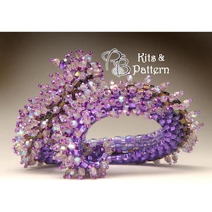 May include: A purple and iridescent beaded bracelet with a unique, spiky design. The bracelet is made with small, faceted beads and has a delicate, feminine look.