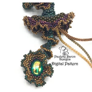 Könnte beinhalten: Nahaufnahme eines Perlen-Schmuckstücks mit einem grün schimmernden Stein in der Mitte. Das Stück besteht aus braunen, goldenen und grünen Perlen und hat ein Spiraldesign. Der Text "Paulette Baron Designs Digital Pattern" ist im Bild sichtbar.