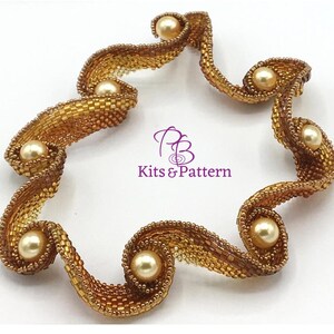May include: A handcrafted, golden-toned beaded bracelet with a swirling, organic design. The bracelet features a series of curves and is adorned with six creamy, round pearls. The text "Kits & Pattern" is visible in the image.