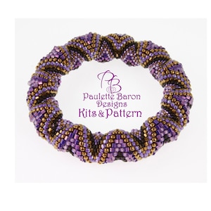 Puede incluir: Un brazalete de cuentas de color morado, marrón y dorado con un diseño en espiral. El brazalete está hecho con cuentas pequeñas y cuadradas y tiene una circunferencia de aproximadamente 18 cm.