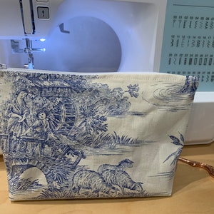 Des boîtes de rangement recouvertes de papier « toile de Jouy