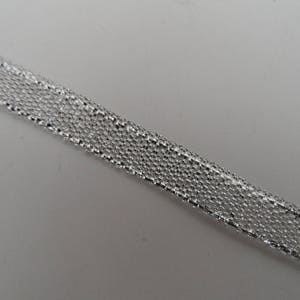 Peut inclure: Ruban métallique argenté avec une finition texturée et scintillante.