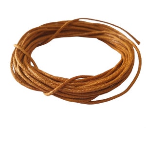 Peut inclure: Une bobine de cordon ciré brun, parfait pour l'artisanat et la fabrication de bijoux.