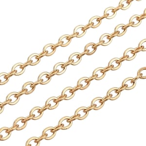 Peut inclure: Gros plan d'une chaîne dorée à maillons ovales. La chaîne est en métal et a une finition brillante.