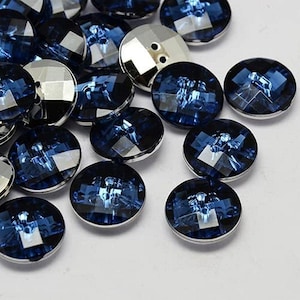 Peut inclure: Assortiment de boutons décoratifs bleus et argentés. Les boutons sont ronds et ont un design facetté.