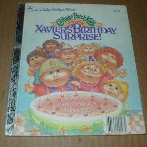 May include: A vintage Little Golden Book titled "Cabbage Patch Kids Present Xavier's Birthday Surprise!" The cover features illustrations of Cabbage Patch Kids around a birthday cake with the text "Happy Birthday Xavier!" in a colorful design.