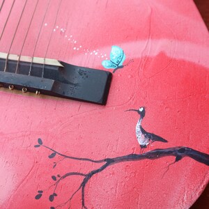 Guitare. Guitare rouge peinte et illustrée. Un couple d'oiseaux sous leur parapluie discutent sur une branche. image 4