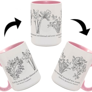 May include: A white ceramic mug with a pink interior and handle, featuring black line-art floral illustrations and text from The Secret Garden by Frances Hodgson Burnett. The mug displays various botanical drawings and quotes in a wrap-around design.