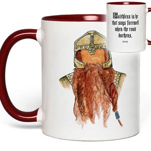 May include: White ceramic mug with a burgundy interior and handle. The mug features a watercolor illustration of a dwarf with a long red beard and a helmet. Text on the mug reads, "Faithless is he that says farewell when the road darkens."