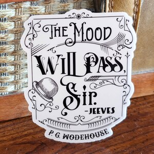 May include: A white sticker with black text that reads "The Mood Will Pass, Sir. - Jeeves" and "P.G. Wodehouse". The sticker has a decorative border and an illustration of a bowler hat.