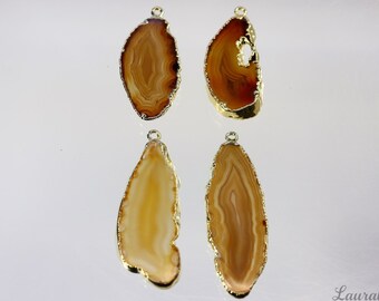 May include: Four agate slices with gold-toned edges, each with a different pattern of brown and white bands. The agate slices are suspended from gold-toned loops.