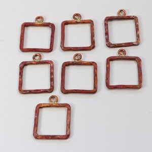 May include: Eight copper square pendant frames with a hammered texture and a loop at the top for hanging.