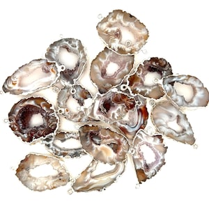 May include: A collection of 14 agate slices with a natural brown and white color pattern. Each slice has a hole drilled through the top for hanging or attaching to jewelry.