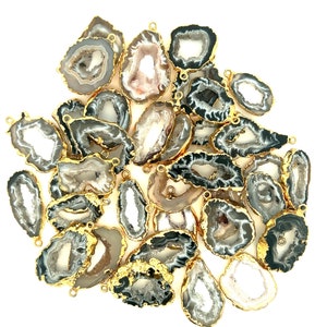 May include: A collection of natural agate pendants with gold-plated edges. The pendants feature a variety of shapes and sizes, showcasing gray, white, and brown color variations. Each pendant has a small loop for attaching to jewelry.