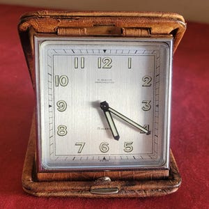 Belle horloge de voyage de chevet vintage dans un étui en cuir