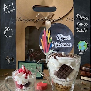 Peut inclure: Deux tasses en verre remplies de cire en forme de chantilly et de garnitures. La grande tasse porte l'inscription Bougies gourmandes Vela Chocolat praline et un carré de chocolat. La petite tasse porte l'inscription Bougies gourmandes Vela Fruits rouges. Un sac cadeau en papier kraft avec un dessin de crayons et le texte Merci Maitresse est placé derrière.
