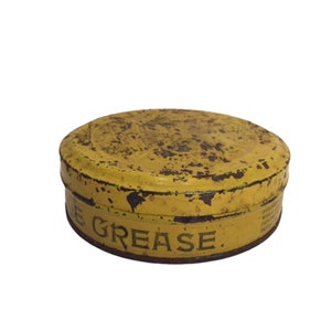 Puede incluir: Una lata de metal amarilla con las palabras "Grease" impresas en el lateral. La lata es vieja y tiene algo de &oacute;xido.