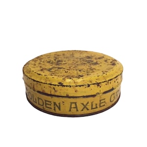 Puede incluir: Una lata de metal amarilla con las palabras "Golden Axle Grease" impresas en el lateral.