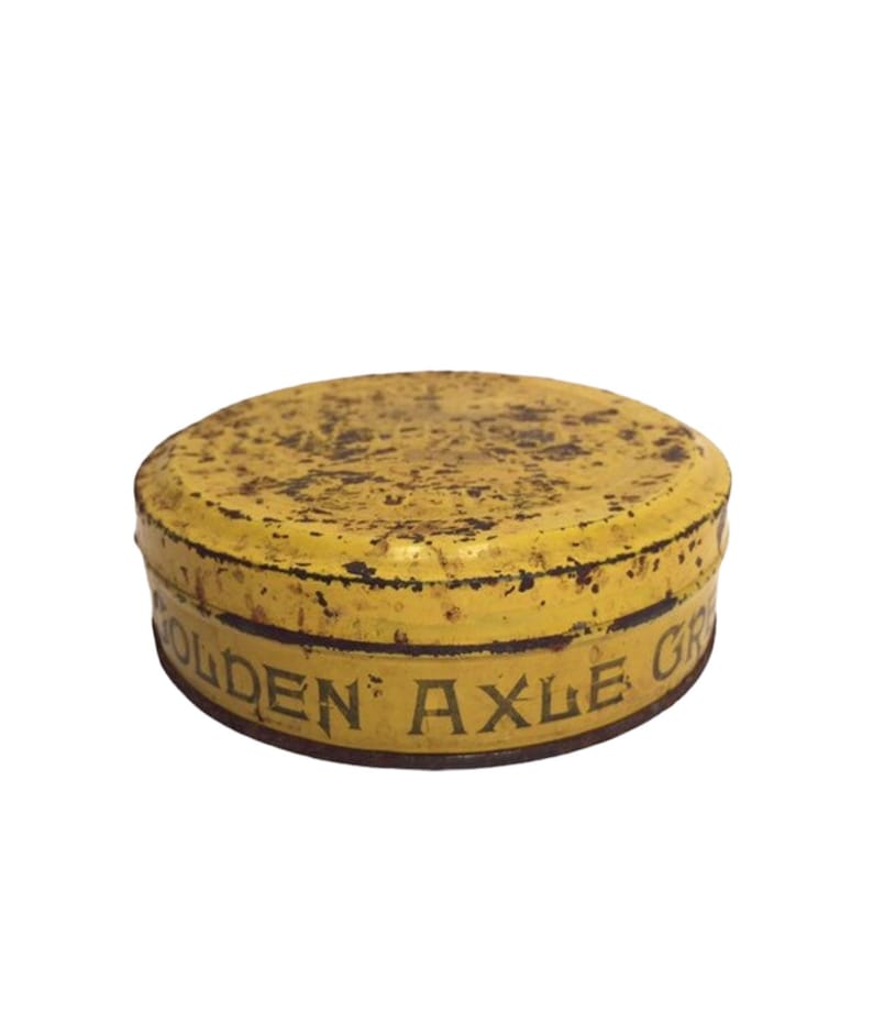 Puede incluir: Una lata de metal amarilla con las palabras "Golden Axle Grease" impresas en el lateral.