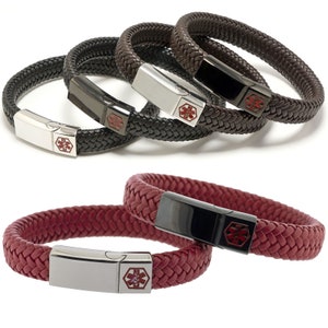Puede incluir: Tres pulseras de cuero trenzado con una etiqueta de alerta médica plateada y negra. Las pulseras son de color negro, marrón y rojo.