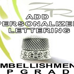 May include: Add personalized lettering to your thimble. Embellishment upgrade.  A silver thimble with a floral design.