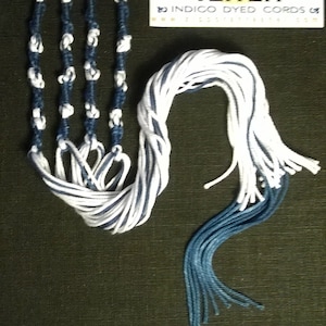 May include: A set of three white and blue tzitzit cords with a tag that reads "Sephardic Traditional Tzitzit Indigo Dyed Cords".