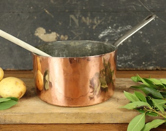 Antique French copper saucepan with its original shop name along its iron handle