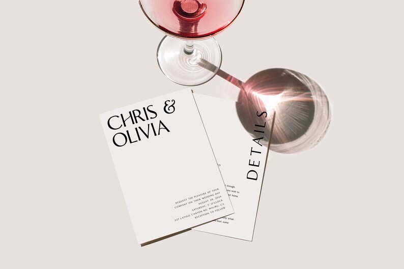 May include: Elegant wedding invitation suite with a glass of pink liquid. The invitation features the names "Chris & Olivia" in a stylish font. The word "DETAILS" is printed on a separate card. The overall design is minimalist and modern.