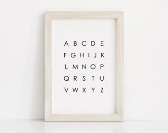 May include: A white wood frame with a white background and black text that reads "A B C D E F G H I J K L M N O P Q R S T U V W X Y Z".