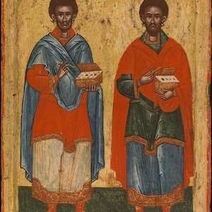 May include: Two figures in a Byzantine icon, both wearing red and blue robes, holding books in their hands. The figures have dark skin and dark hair. The background is a gold color.