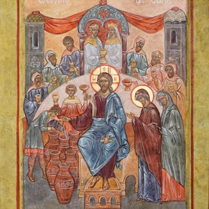 Op de afbeelding: Een icoon die de Bruiloft te Kana afbeeldt, met figuren in gewaden en halo's. De scène omvat Jezus, een bruid en bruidegom, en bedienden met kelken. De tekst "Wedding at Cana" staat bovenaan. Het kunstwerk is omlijst met een gouden rand.