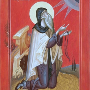May include: A religious icon painting of a bearded man in a white robe and black hood, kneeling and holding a rosary. The background is red with a sunburst and the text "Ο άγιος Κασσιανός" in Greek.