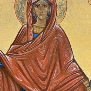 May include: A painting of a woman wearing a red robe and a blue dress. She has a halo around her head and is looking directly at the viewer. The painting is done in a traditional style.