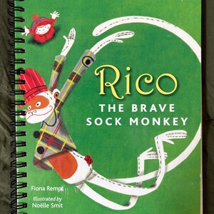 May include: A spiral-bound children's book titled "Rico The Brave Sock Monkey" with a green cover. The cover features a cartoon sock monkey with a red hat and plaid jacket. The book is part of the "Little Golden Book" series.