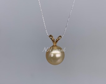 May include: A golden pendant necklace with a single, large, round, golden pearl. The pearl is attached to a delicate gold chain.
