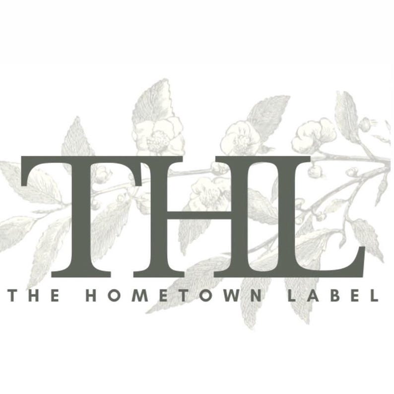 May include: Black and white illustration of a floral design with the text "THE HOMETOWN LABEL" and the letters "THL" in a large font.