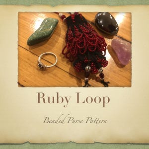 May include: A close-up of a beaded purse pattern called "Ruby Loop". The purse is red and black with silver beads and tassels. The image also includes a green stone, a black stone, a purple stone, and a silver ring.
