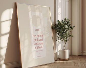 May include: A white door hanger with a gold frame. The text on the door hanger reads "The Sunday Standard. I'm eating junk and watching rubbish. I might be hungover."