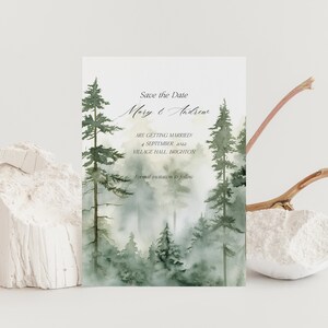 May include: Save the Date card with a watercolor illustration of a misty forest with tall pine trees. The text reads "Save the Date Mary & Andrew Are Getting Married 4 September 2022 Village Hall Brighton Formal Invitations to Follow"