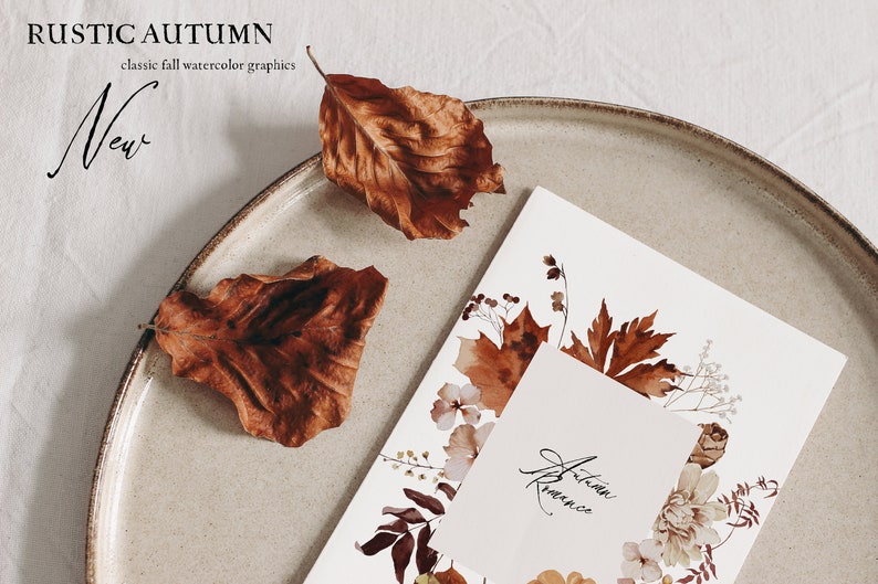Op de afbeelding: Een aquarel-illustratie van herfstbladeren en bloemen op een witte kaart met de tekst "Herfstromantiek" op een kleinere witte kaart. De kaart ligt op een beige bord met twee bruine bladeren.